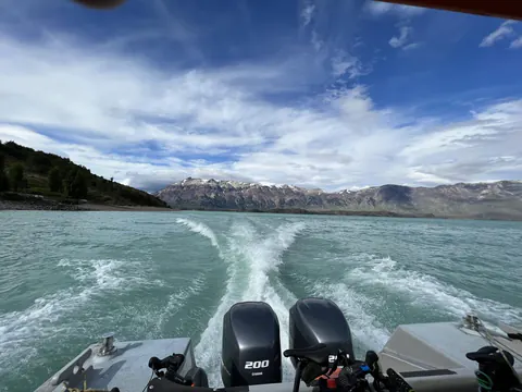 La estela de la lancha sobre el agua turquesa del lago O'Higgins, con cerros nevados al fondo