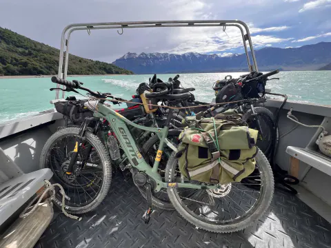 E-Bikes con alforjas amarradas en la cubierta de una lancha, sobre el agua turquesa del lago O'Higgins