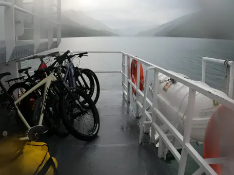 Bicicletas amarradas en la cubierta del barco que cruza el Lago del Desierto, con niebla sobre el agua