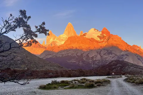 El Fitz Roy encendido de naranja al amanecer, al final de un camino de ripio