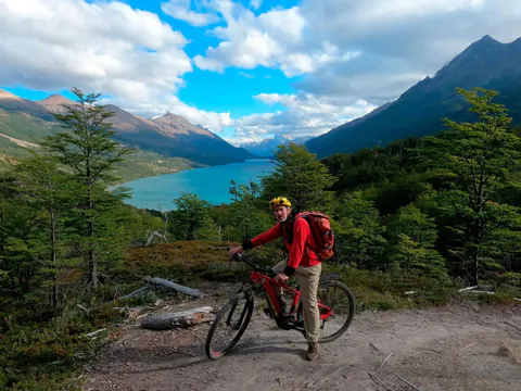 Un rider en e-Bike en un mirador sobre el Lago del Desierto, entre montañas y bosque