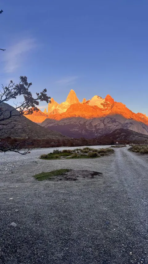 El Fitz Roy encendido de naranja al amanecer, al final de un camino de ripio