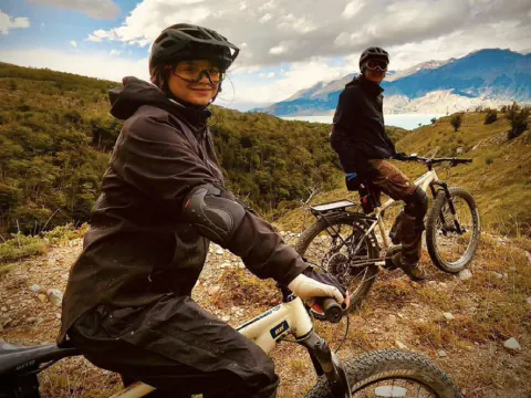 Dos riders con casco en sus e-Bikes, en un mirador sobre el lago O'Higgins, en Candelario Mancilla